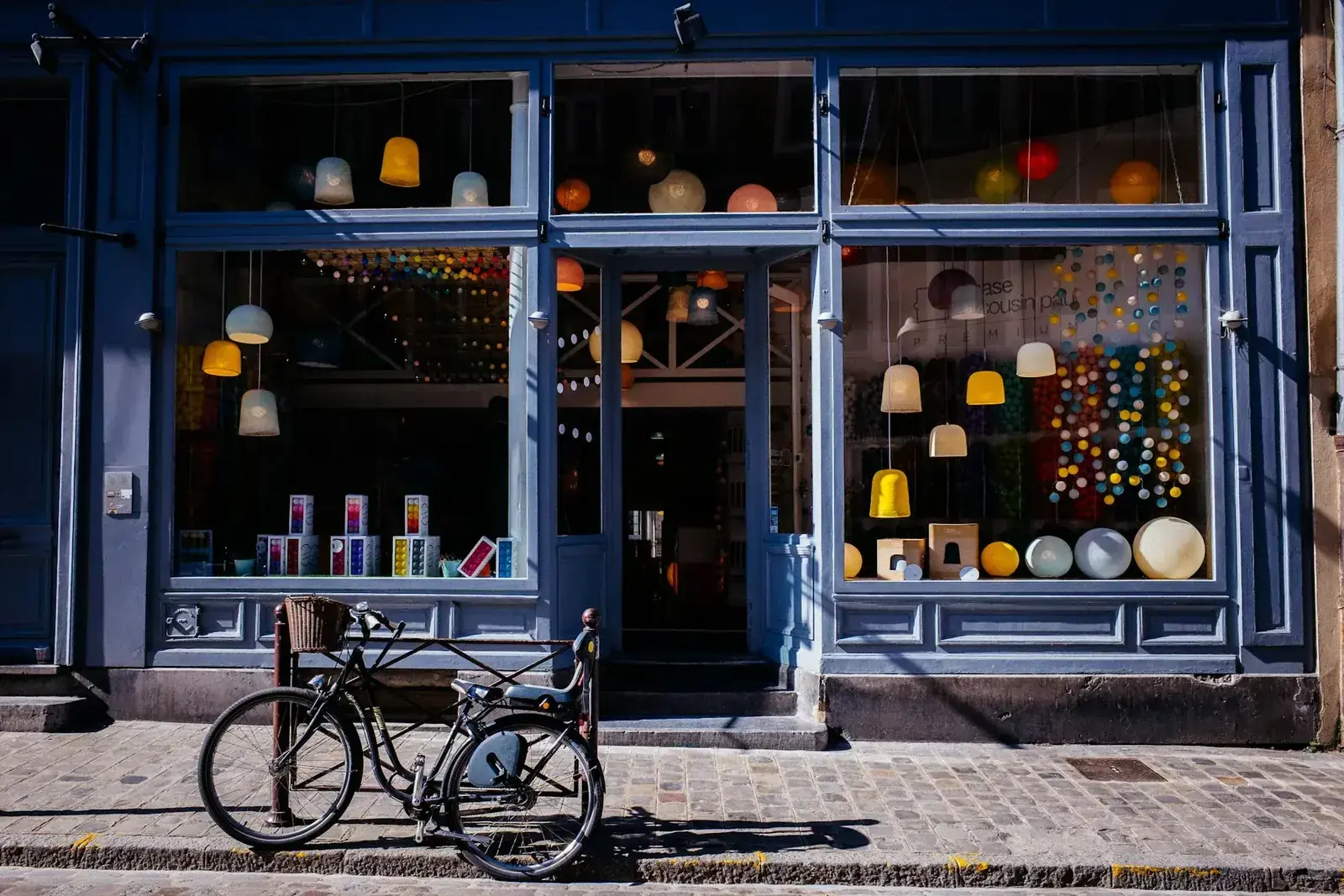 A lit storefront in the evening with a bicycle parked outside.