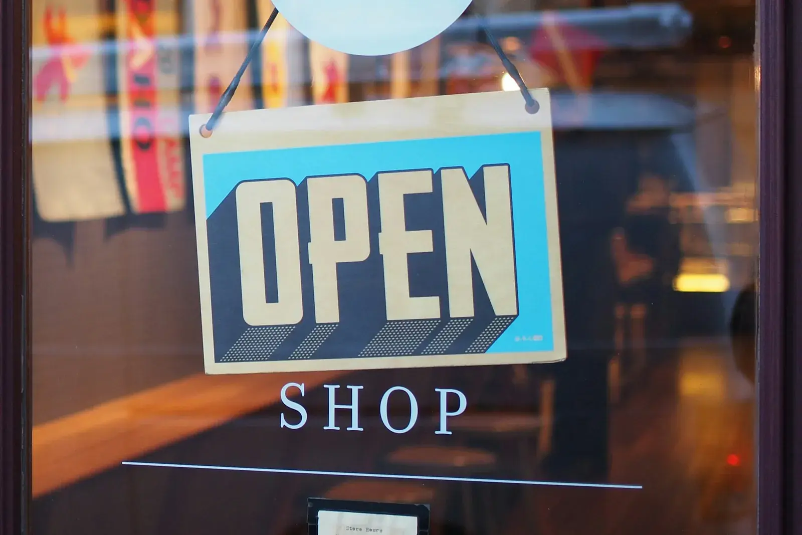 An OPEN sign hanging in a shop window, seen from the street.