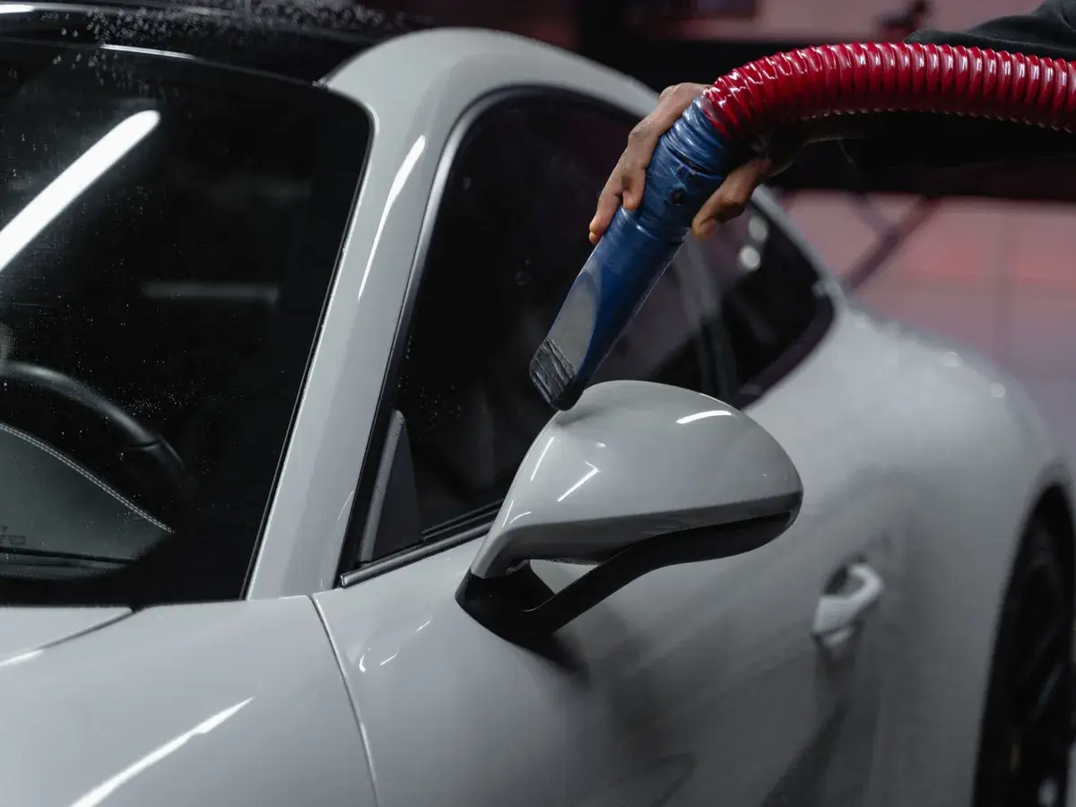 A car being blown dry in a detailing bay.