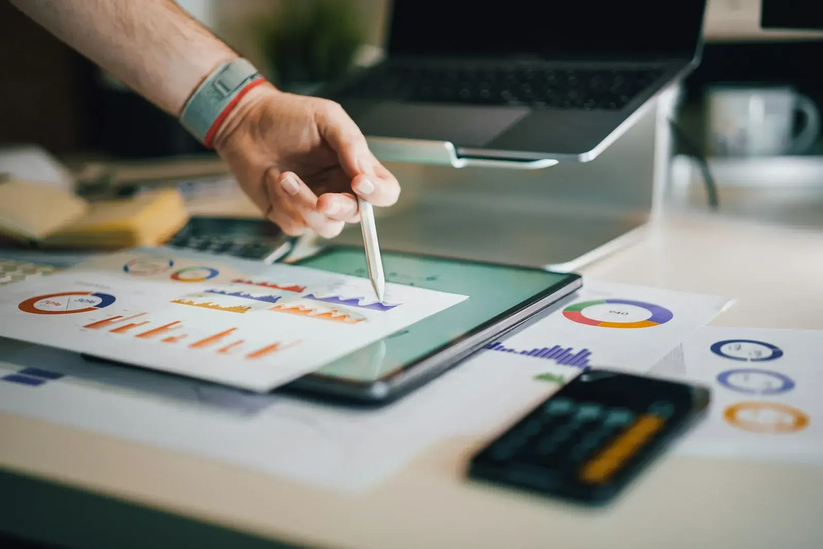Someone going through printed campaign charts next to a laptop.